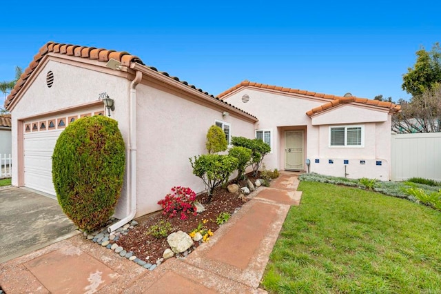 mediterranean / spanish-style house featuring a front yard, fence, driveway, an attached garage, and stucco siding