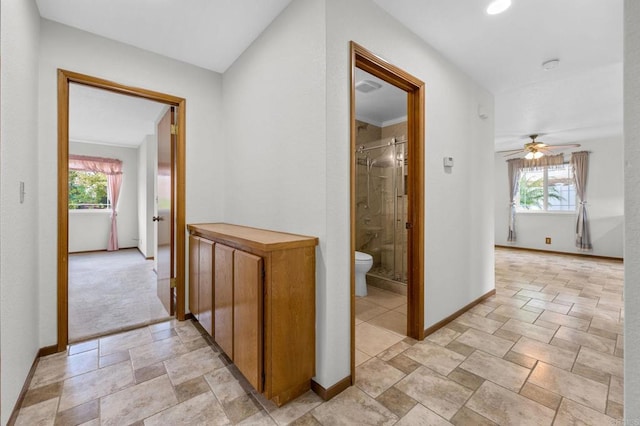 corridor featuring visible vents, stone finish floor, and baseboards