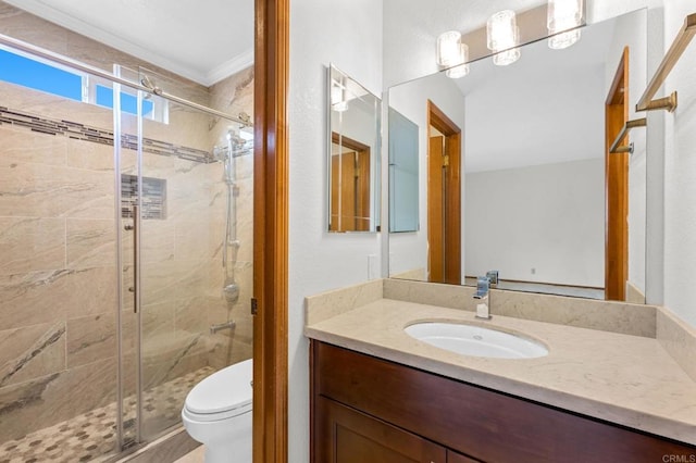 bathroom featuring a stall shower, toilet, vanity, and crown molding