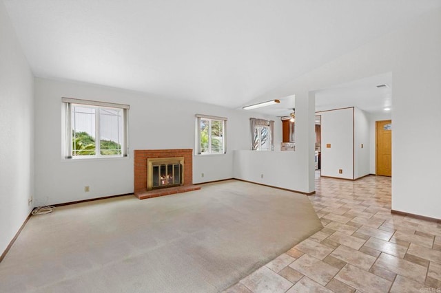 unfurnished living room featuring carpet, a brick fireplace, and a healthy amount of sunlight