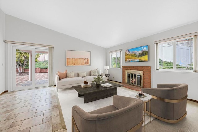 living area with baseboards, a brick fireplace, and vaulted ceiling