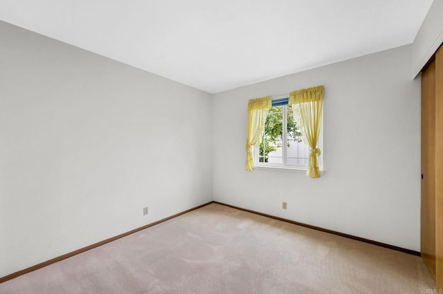 unfurnished room featuring baseboards and carpet