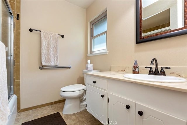 full bath featuring vanity, baseboards, tile patterned floors, toilet, and combined bath / shower with glass door