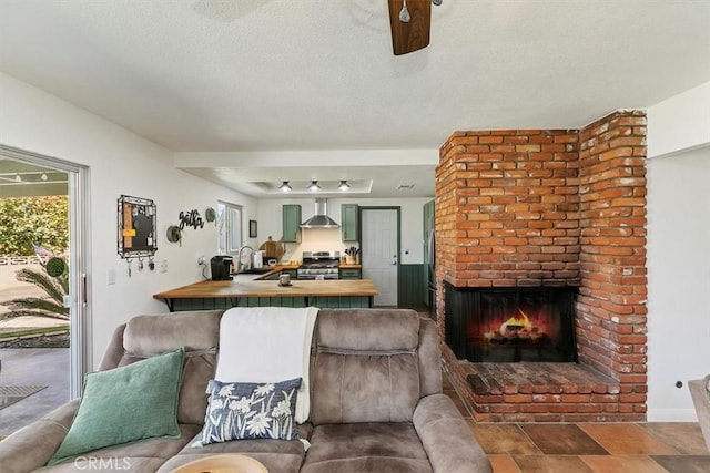 living area with a textured ceiling and a fireplace