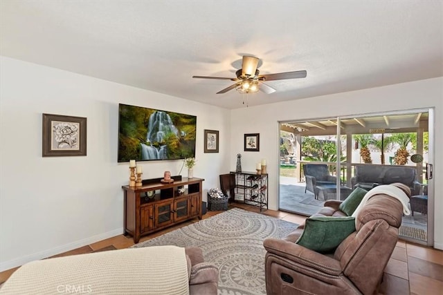 tiled living room featuring a ceiling fan, baseboards, a sunroom, and a textured ceiling