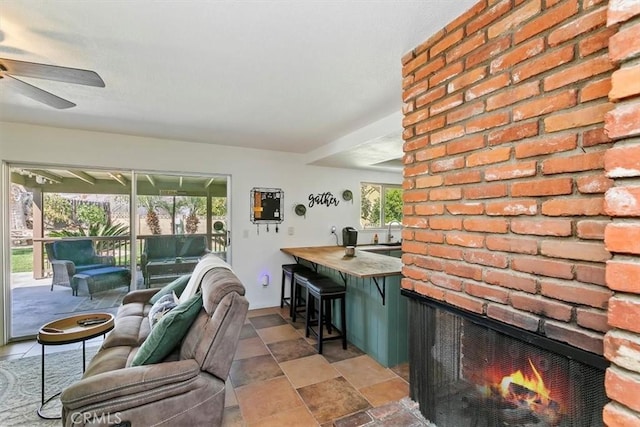 interior space featuring stone finish floor, a fireplace, and ceiling fan