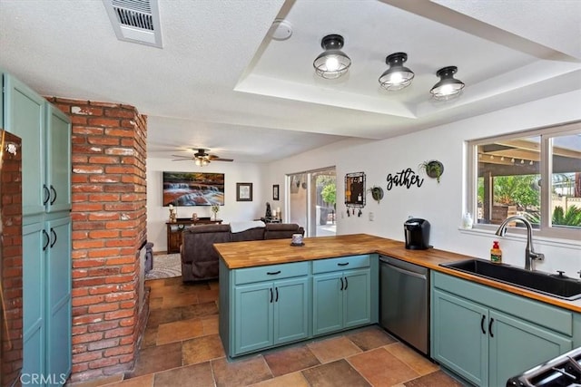 kitchen featuring visible vents, dishwasher, wood counters, a raised ceiling, and a sink