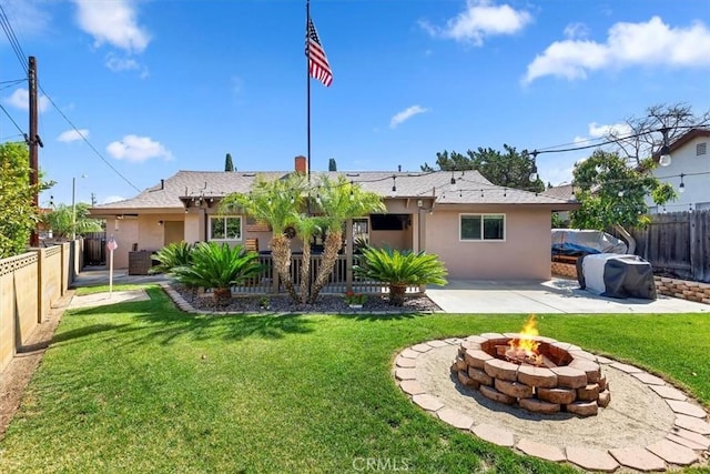 back of house featuring stucco siding, a patio, a yard, and a fenced backyard