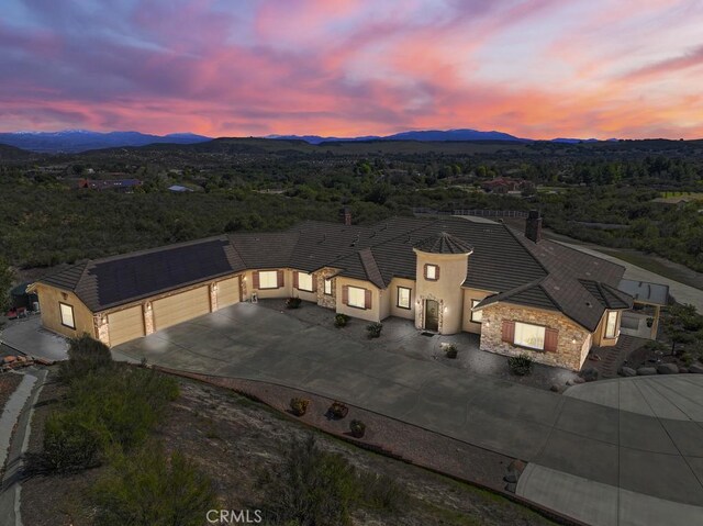 aerial view at dusk featuring a mountain view