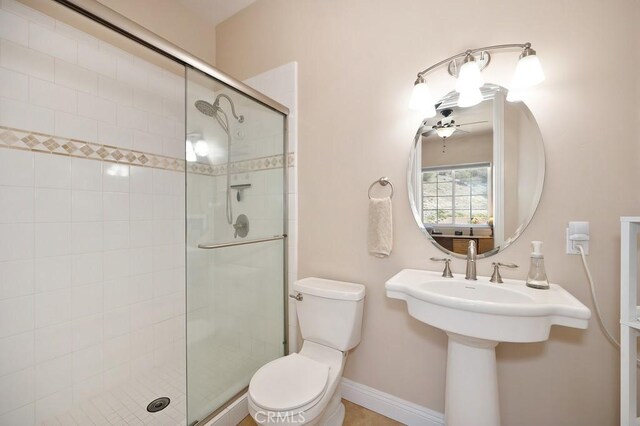 full bathroom with baseboards, toilet, and a stall shower