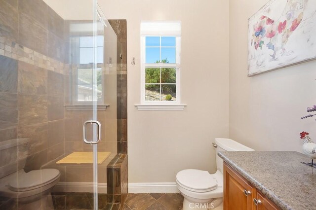 full bathroom featuring a shower stall, toilet, vanity, and baseboards