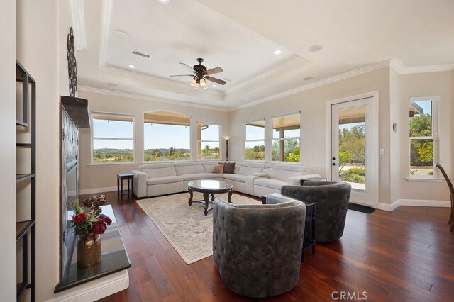 living area with visible vents, crown molding, a raised ceiling, and dark wood-type flooring