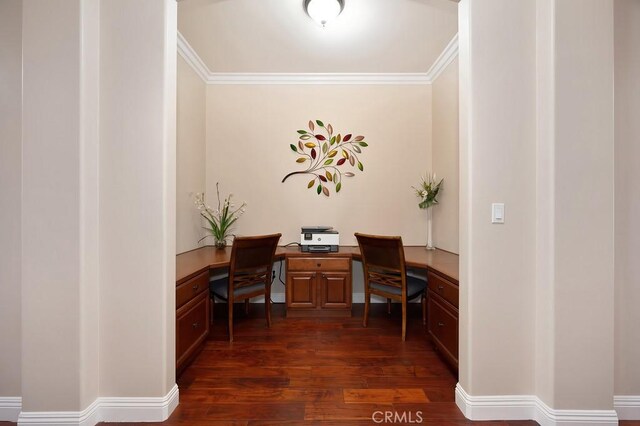 office area featuring built in study area, crown molding, baseboards, and dark wood-style flooring