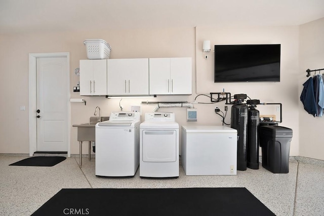 clothes washing area with a sink, cabinet space, and washing machine and clothes dryer