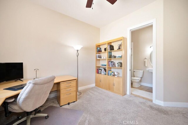 office area featuring a ceiling fan, baseboards, and light carpet