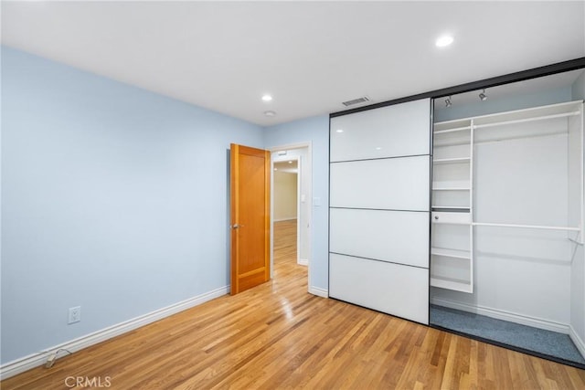 unfurnished bedroom with light wood-type flooring, visible vents, recessed lighting, a closet, and baseboards