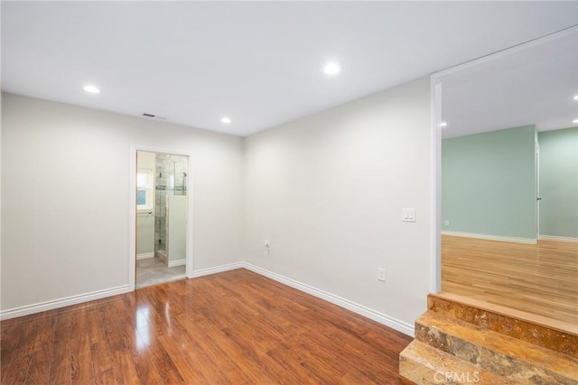 spare room featuring recessed lighting, visible vents, baseboards, and wood finished floors