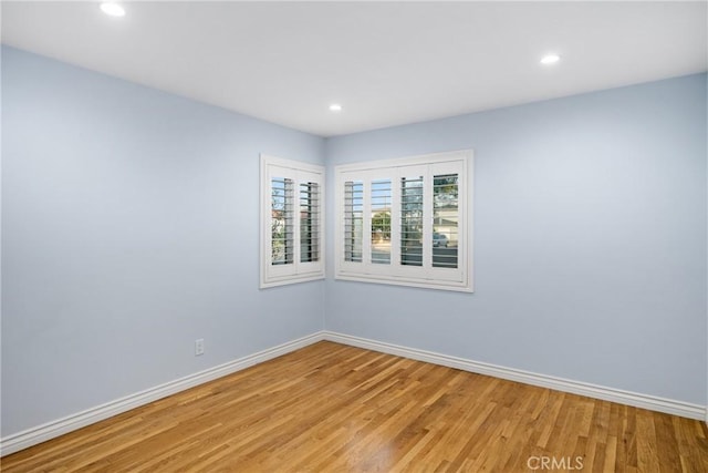 unfurnished room with recessed lighting, baseboards, and light wood-type flooring