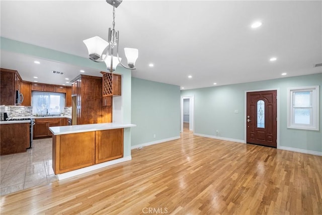 kitchen with tasteful backsplash, open floor plan, stainless steel appliances, and light countertops