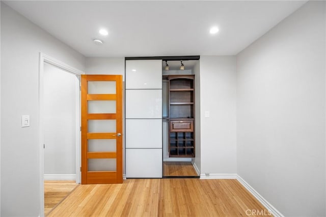 unfurnished bedroom featuring recessed lighting, light wood-type flooring, and baseboards