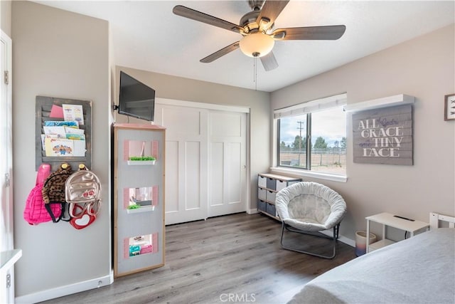 bedroom featuring a ceiling fan, wood finished floors, a closet, and baseboards