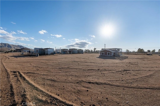 view of yard with an outbuilding, a rural view, and fence