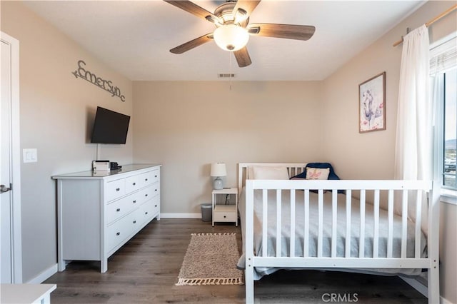 bedroom with a ceiling fan, wood finished floors, visible vents, and baseboards