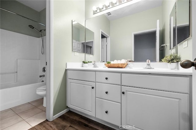 full bathroom featuring tile patterned flooring, toilet, shower / tub combination, double vanity, and a sink