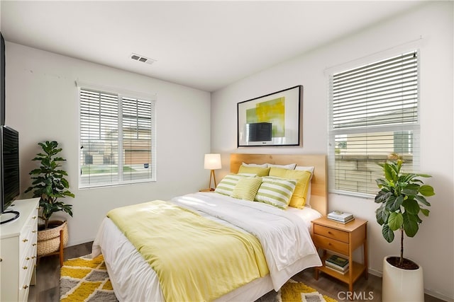 bedroom featuring wood finished floors, visible vents, and baseboards