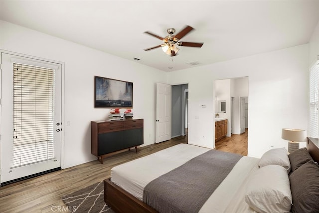 bedroom featuring ceiling fan, light wood-type flooring, visible vents, and ensuite bath