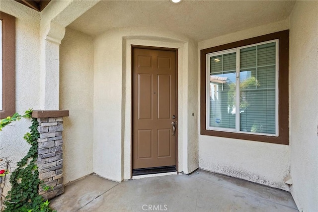 view of exterior entry with stucco siding