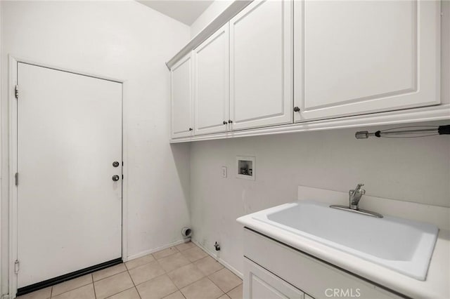 laundry room featuring hookup for a washing machine, baseboards, light tile patterned flooring, cabinet space, and a sink