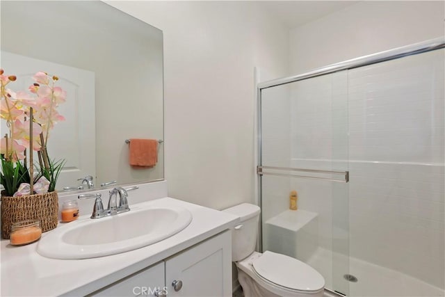 bathroom with vanity, toilet, and a shower stall