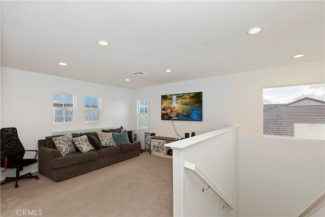 living area featuring recessed lighting, visible vents, and light colored carpet