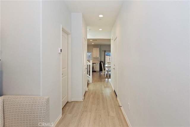 hall featuring recessed lighting, light wood-style flooring, and baseboards