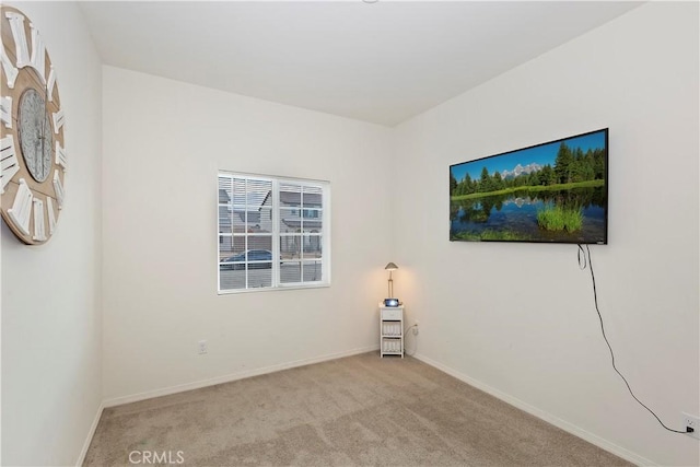 carpeted empty room featuring baseboards