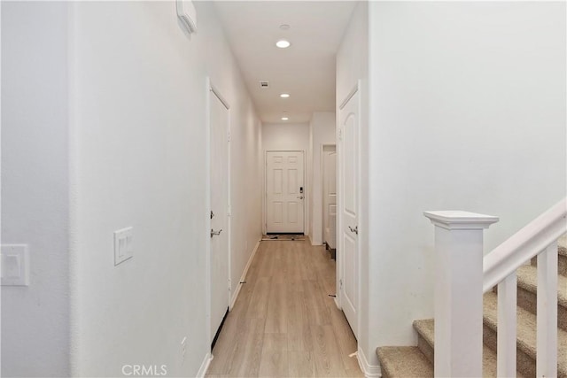 corridor featuring recessed lighting, stairway, baseboards, and light wood-style floors