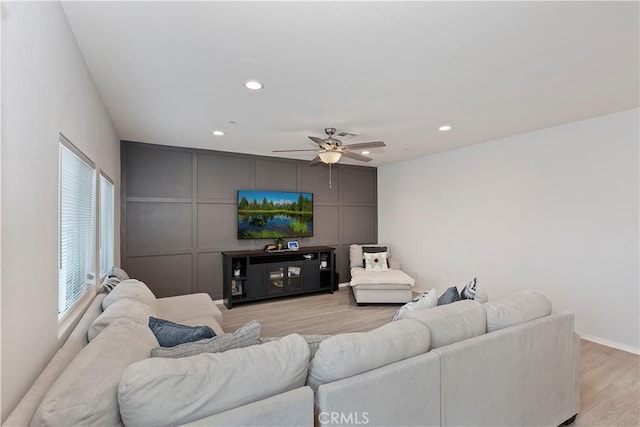 living area with recessed lighting, light wood finished floors, a ceiling fan, and a decorative wall