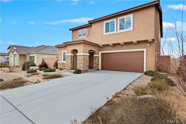 mediterranean / spanish home featuring a tile roof, stucco siding, driveway, stone siding, and an attached garage