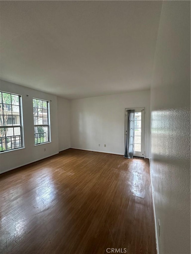 unfurnished room with dark wood-style flooring