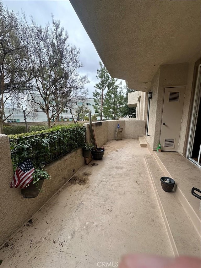 view of patio featuring a balcony and visible vents