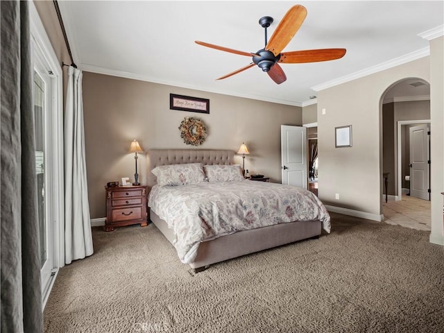 bedroom featuring a ceiling fan, baseboards, arched walkways, crown molding, and carpet flooring