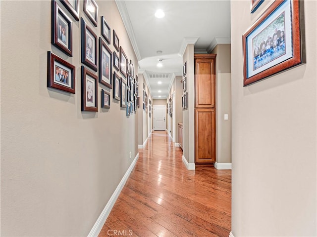 hall with recessed lighting, light wood-type flooring, baseboards, and ornamental molding