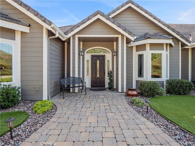 view of exterior entry featuring a tile roof