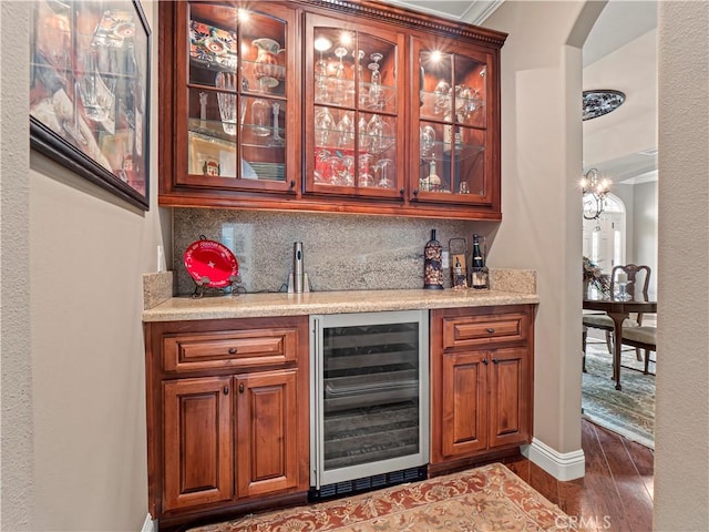 bar with dark wood-style floors, arched walkways, decorative backsplash, indoor wet bar, and wine cooler