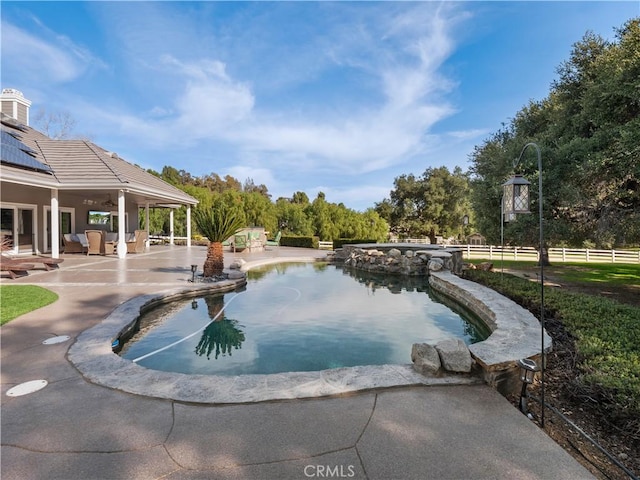 outdoor pool featuring a patio and fence