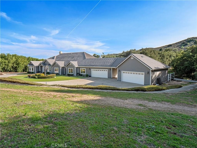 view of front of home with driveway, an attached garage, and a front yard