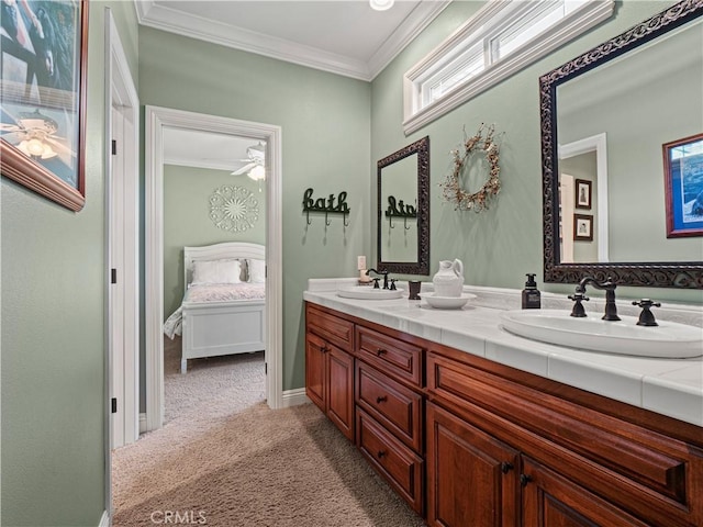 ensuite bathroom with ornamental molding, connected bathroom, double vanity, and a sink