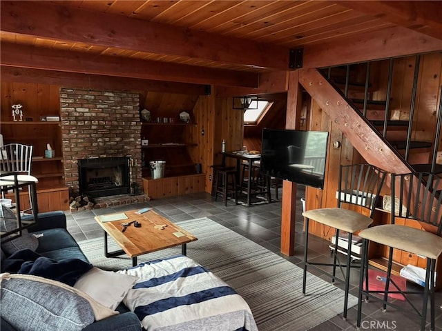 living area featuring stairs, wooden ceiling, wood walls, and beam ceiling