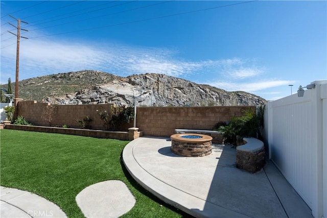 6594 June Mountain Way, Jurupa Valley, CA 92509 - view of yard featuring a mountain view, a fire pit, a fenced backyard, and a patio area